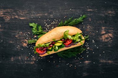 Burger, avokado sandviç, kiraz domates ve marul yaprakları. Ahşap bir arka plan üzerinde. Üstten Görünüm. Kopya alanı.