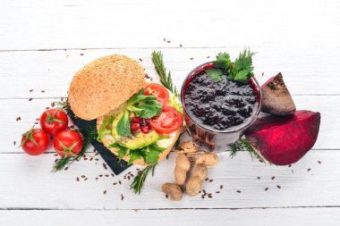 Kahvaltı. Pancar suyu ve avokado burger ve sebze. Ahşap bir arka plan üzerinde. Üstten Görünüm. Kopya alanı.