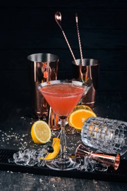 Alkol kokteyli Cosmopolitan. Siyah arka plan çubuğunda.