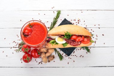 Kahvaltı. Domates suyu ve burger salam ve sebze. Ahşap bir arka plan üzerinde. Üstten Görünüm. Kopya alanı.