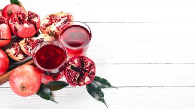 Taze nar suyu. Nar. Beyaz ahşap zemin üzerinde. Üstten Görünüm. Kopya alanı.