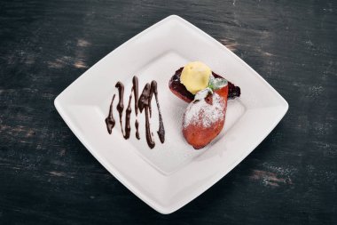 Tatlı. Karamelize armut bir plaka üzerinde dondurma ile. Ahşap bir arka plan üzerinde. Üstten Görünüm. Kopya alanı.