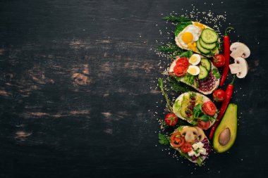 Burger ayarla, sandviç. Bıldırcın yumurta, salatalık ve Mısır, salam ve deniz ürünleri ile. Ahşap bir arka plan üzerinde. Üstten Görünüm. Kopya alanı.