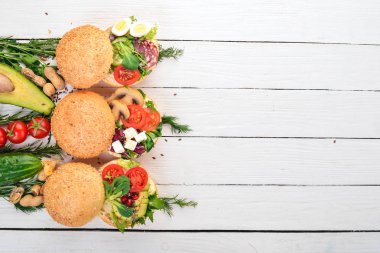 Burger ayarla, sandviç. Bıldırcın yumurta, salatalık ve Mısır, salam ve deniz ürünleri ile. Ahşap bir arka plan üzerinde. Üstten Görünüm. Kopya alanı.