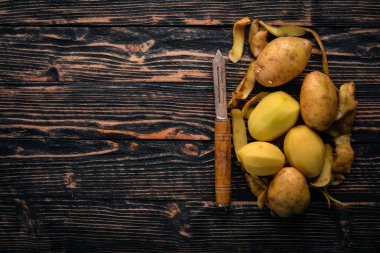 Çiğ patates. Kahverengi ahşap zemin üzerinde. Yemek. Metin için özgür yer. Üstten Görünüm.