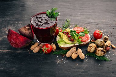 Kahvaltı. Pancar suyu ve avokado burger ve sebze. Ahşap bir arka plan üzerinde. Üstten Görünüm. Kopya alanı.