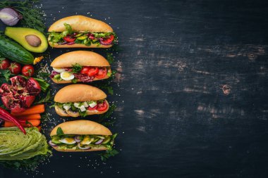 Burger ayarla, sandviç. Bıldırcın yumurta, salatalık ve Mısır, salam ve deniz ürünleri ile. Ahşap bir arka plan üzerinde. Üstten Görünüm. Kopya alanı.