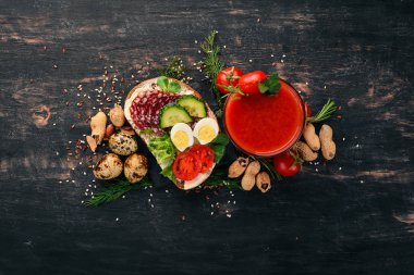 Kahvaltı. Domates suyu ve burger salam ve sebze. Ahşap bir arka plan üzerinde. Üstten Görünüm. Kopya alanı.