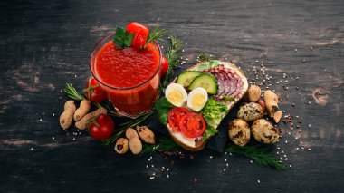 Kahvaltı. Domates suyu ve burger salam ve sebze. Ahşap bir arka plan üzerinde. Üstten Görünüm. Kopya alanı.