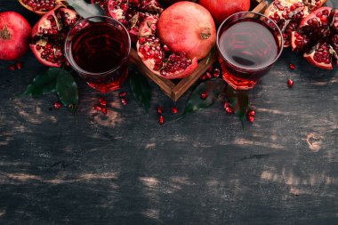 Taze nar suyu. Nar. Siyah ahşap arka plan üzerinde. Üstten Görünüm. Kopya alanı.