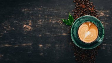 Siyah ahşap zemin kahve Cappuccino kokulu bir fincan. Üstten Görünüm. Kopya alanı.