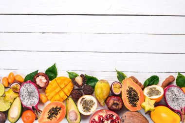 Tropikal meyveler, papaya, Dragon meyve, rambutan, demirhindi, kaktüs meyve, avokado, granadilla, carambola, Kamkat, mango, mangosten, Çarkıfelek, Hindistan cevizi. Ahşap bir arka plan üzerinde.