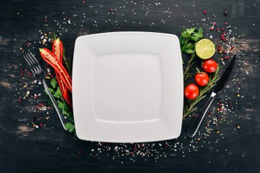 Pişirme arka plan. Taze sebze ile plaka. Bir ahşap yüzeye. Üstten Görünüm. Kopya alanı.