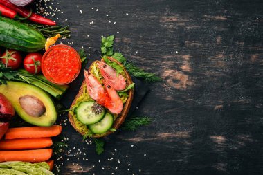 Burger, karides, avokado, havyar ve salatalık sandviç. Ahşap bir arka plan üzerinde. Üstten Görünüm. Kopya alanı.