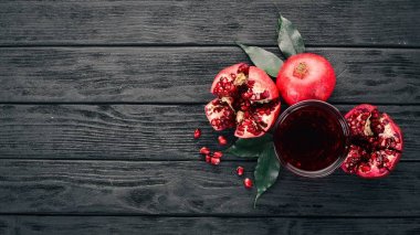 Taze nar suyu. Nar. Siyah ahşap arka plan üzerinde. Üstten Görünüm. Kopya alanı.