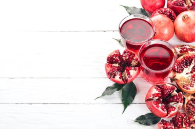 Taze nar suyu. Nar. Beyaz ahşap zemin üzerinde. Üstten Görünüm. Kopya alanı.