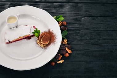 Tatlı. Strudel berry reçel ve bir plaka üzerinde dondurma ile. Ahşap bir arka plan üzerinde. Üstten Görünüm. Kopya alanı.