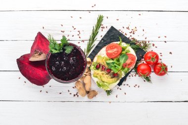 Kahvaltı. Pancar suyu ve avokado burger ve sebze. Ahşap bir arka plan üzerinde. Üstten Görünüm. Kopya alanı.