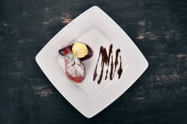 Tatlı. Karamelize armut bir plaka üzerinde dondurma ile. Ahşap bir arka plan üzerinde. Üstten Görünüm. Kopya alanı.