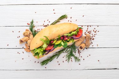 Burger, avokado sandviç, kiraz domates ve marul yaprakları. Ahşap bir arka plan üzerinde. Üstten Görünüm. Kopya alanı.