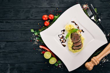 Dana dil bir tabak patates püresi ile haşlanmış. Ahşap bir arka plan üzerinde. Üstten Görünüm. Kopya alanı.