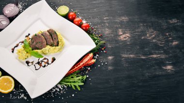 Dana dil bir tabak patates püresi ile haşlanmış. Ahşap bir arka plan üzerinde. Üstten Görünüm. Kopya alanı.