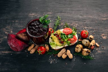 Kahvaltı. Pancar suyu ve avokado burger ve sebze. Ahşap bir arka plan üzerinde. Üstten Görünüm. Kopya alanı.