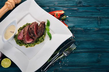 Peper biftek ıspanaklı Dana eti. Ahşap bir arka plan üzerinde. Üstten Görünüm. Kopya alanı.