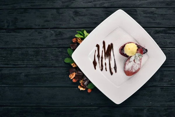 Tatlı. Karamelize armut bir plaka üzerinde dondurma ile. Ahşap bir arka plan üzerinde. Üstten Görünüm. Kopya alanı.