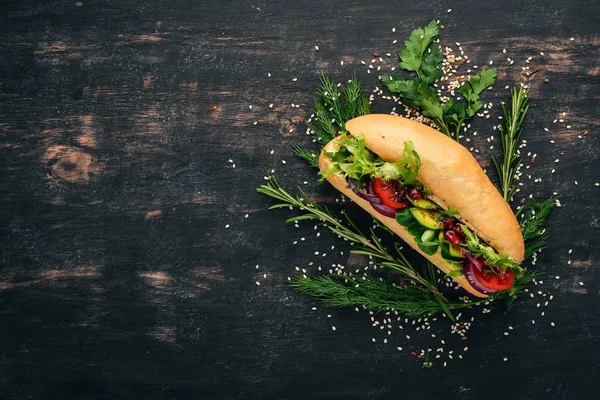 Burger, avokado sandviç, kiraz domates ve marul yaprakları. Ahşap bir arka plan üzerinde. Üstten Görünüm. Kopya alanı.