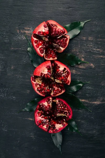Fresh pomegranate. On a black wooden background. Top view. Copy space.
