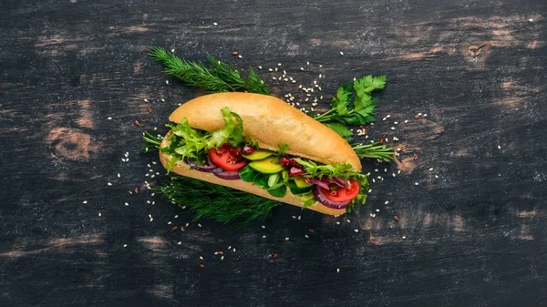 Burger, avokado sandviç, kiraz domates ve marul yaprakları. Ahşap bir arka plan üzerinde. Üstten Görünüm. Kopya alanı.