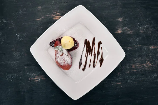 Tatlı. Karamelize armut bir plaka üzerinde dondurma ile. Ahşap bir arka plan üzerinde. Üstten Görünüm. Kopya alanı.