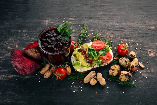 Kahvaltı. Pancar suyu ve avokado burger ve sebze. Ahşap bir arka plan üzerinde. Üstten Görünüm. Kopya alanı.