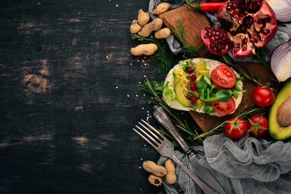 Burger, avokado sandviç, kiraz domates ve marul yaprakları. Ahşap bir arka plan üzerinde. Üstten Görünüm. Kopya alanı.