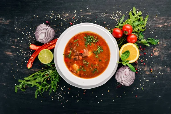 Soup with beef tomatoes and fresh vegetables. On a wooden background. Top view. Copy space. — Stock Image Soup Beef Tomatoes Fresh Vegetables Wooden Background Top View Copy Royalty Free Stock Photos