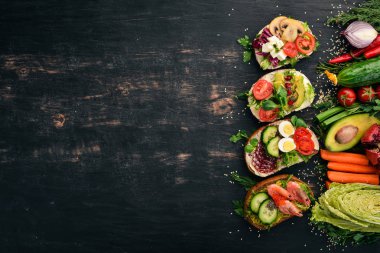 Burger ayarla, sandviç. Bıldırcın yumurta, salatalık ve Mısır, salam ve deniz ürünleri ile. Ahşap bir arka plan üzerinde. Üstten Görünüm. Kopya alanı.