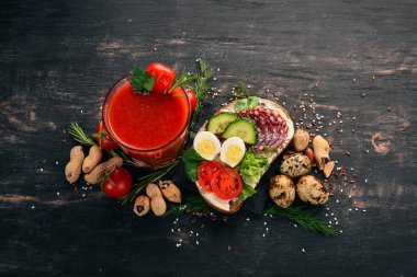 Kahvaltı. Domates suyu ve burger salam ve sebze. Ahşap bir arka plan üzerinde. Üstten Görünüm. Kopya alanı.