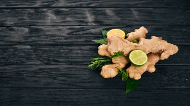 Taze zencefil, limon ve kireç ahşap arka plan üzerinde. Üstten Görünüm. Kopya alanı.