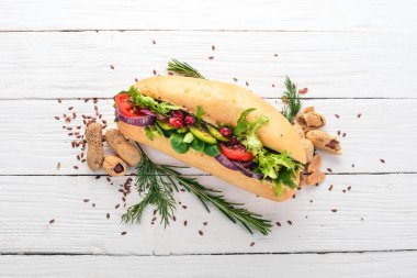 Burger, avokado sandviç, kiraz domates ve marul yaprakları. Ahşap bir arka plan üzerinde. Üstten Görünüm. Kopya alanı.