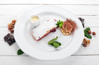 Tatlı. Strudel berry reçel ve bir plaka üzerinde dondurma ile. Ahşap bir arka plan üzerinde. Üstten Görünüm. Kopya alanı.