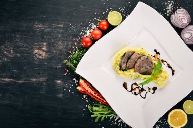 Dana dil bir tabak patates püresi ile haşlanmış. Ahşap bir arka plan üzerinde. Üstten Görünüm. Kopya alanı.