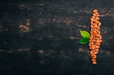 Fındık badem. Siyah ahşap arka plan üzerinde. Üstten Görünüm. Metin için yer kopyalayın.