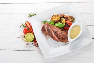 Domuz eti biftek bir plaka üzerinde ızgara sebzeler ile. Ahşap bir arka plan üzerinde. Üstten Görünüm. Kopya alanı.