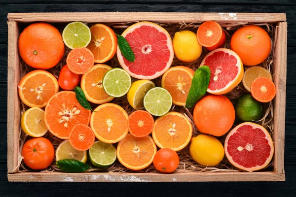 木製の箱に柑橘系の果物を盛り合わせ オレンジ タンジェリン グレープ フルーツ レモン 木製の背景 平面図です コピー スペース — ストック写真