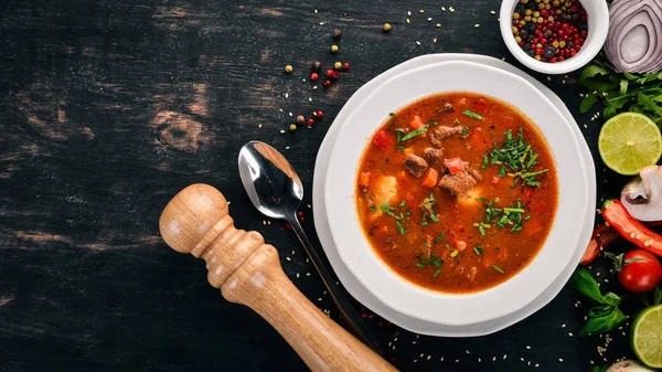 Soup with beef tomatoes and fresh vegetables. On a wooden background. Top view. Copy space. — Stock Image Soup Beef Tomatoes Fresh Vegetables Wooden Background Top View Copy Royalty Free Stock Images