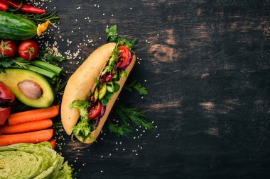 Burger, avokado sandviç, kiraz domates ve marul yaprakları. Ahşap bir arka plan üzerinde. Üstten Görünüm. Kopya alanı.