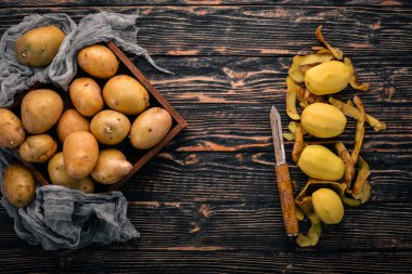 Çiğ patates. Kahverengi ahşap zemin üzerinde. Yemek. Metin için özgür yer. Üstten Görünüm.