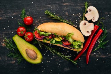 Burger, avokado sandviç, kiraz domates ve marul yaprakları. Ahşap bir arka plan üzerinde. Üstten Görünüm. Kopya alanı.