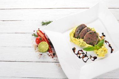 Dana dil bir tabak patates püresi ile haşlanmış. Ahşap bir arka plan üzerinde. Üstten Görünüm. Kopya alanı.